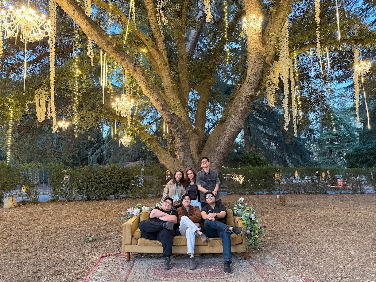 Six of us on a couch under an oak strung with chandeliers