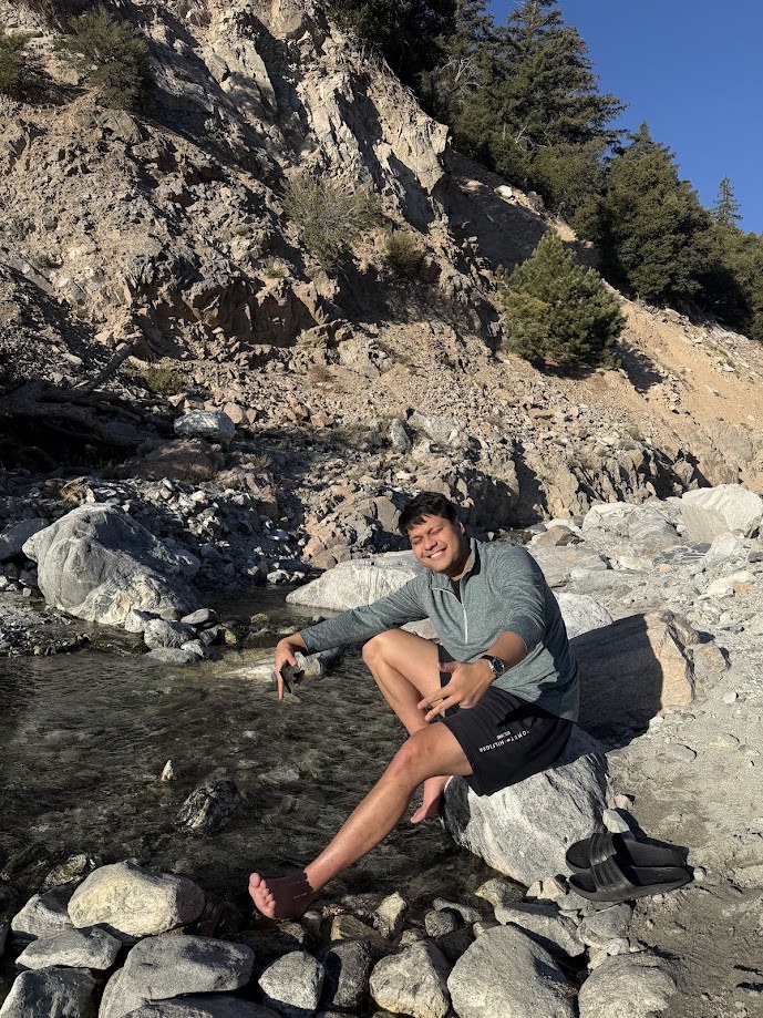 Sitting on the rocks taking my shoes off at a creek up in the mountains
